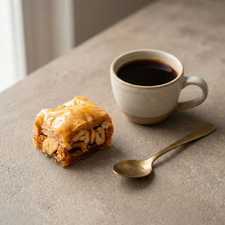 Cashew square baklava beside a coffee cup showing size