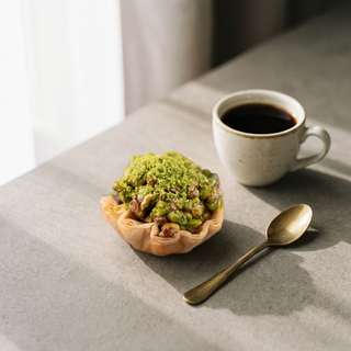 Pistachio Tart Baklava beside a coffee cup showing size